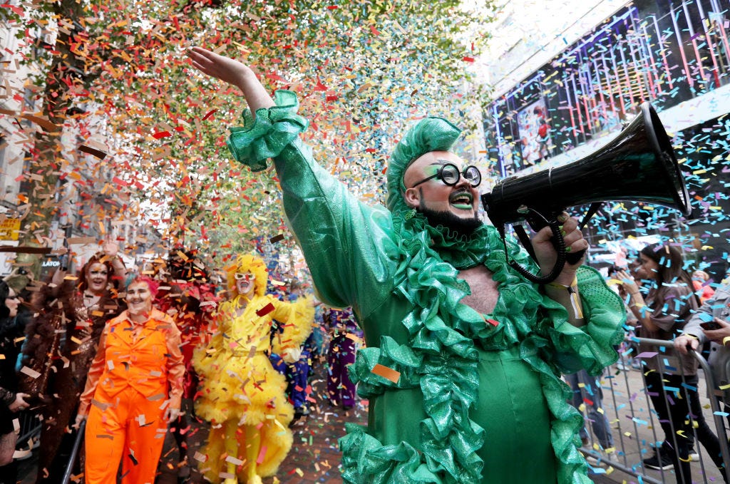 Confetti! Brightly colored queers ! Gorgeous human with makeup and a megaphone!