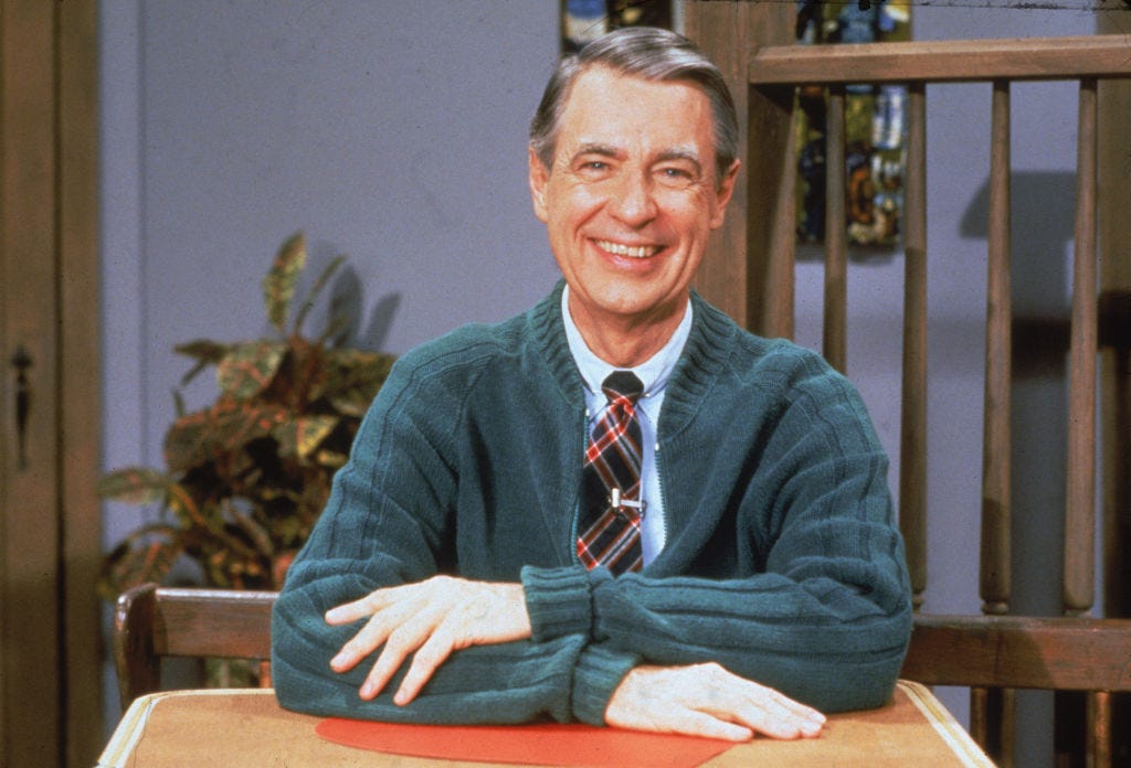 Rev. Fred Rogers in a blue sweater and tie looking friendly