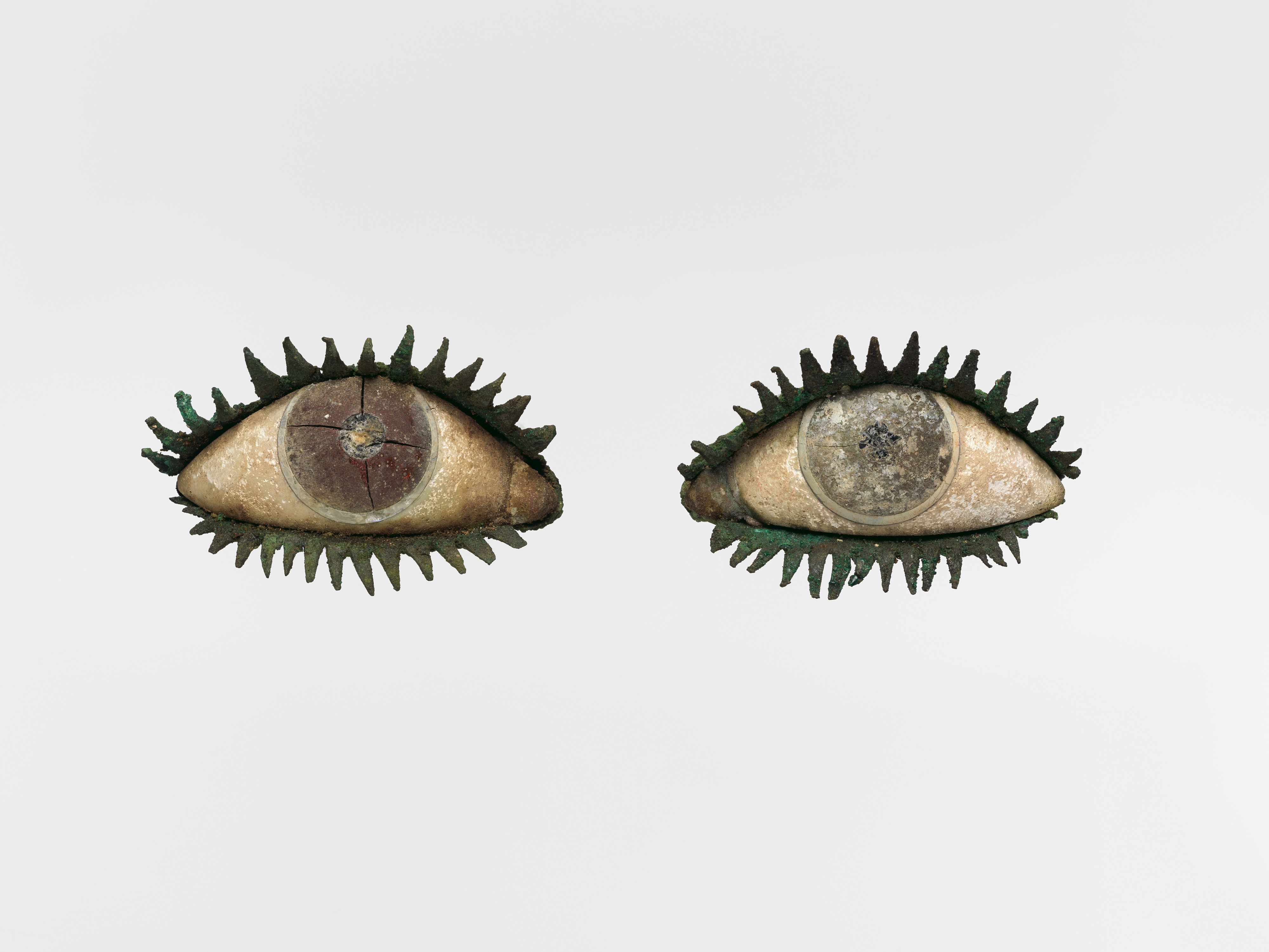 Two groovy eyes made out of wood, with metal eyelashes