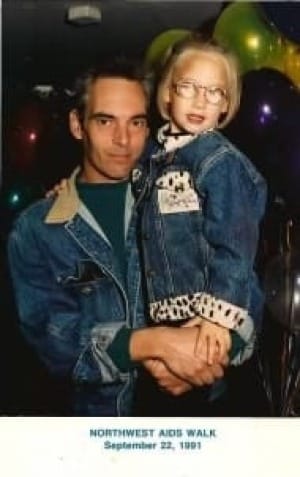 white man holding a small blonde white child with glasses, both in jean jackets