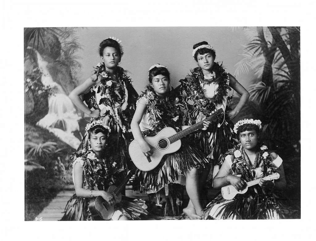 Five Hawaiian women with ukuleles and guitars and traditional clothing, black and white photography. Photo from 1906. 