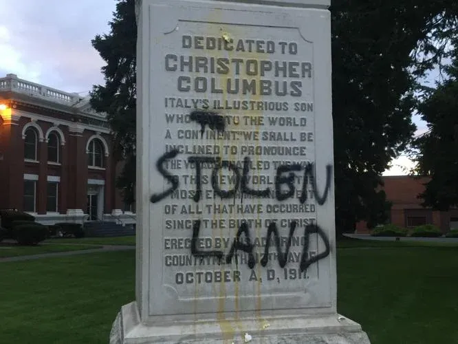 A dedication stone to Christopher Columbus and STOLEN LAND is graffiti'd on top of it