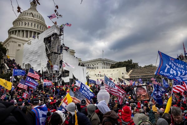 Image of the capitol building being stormed by Jan 6 coup goons and trump and US flags